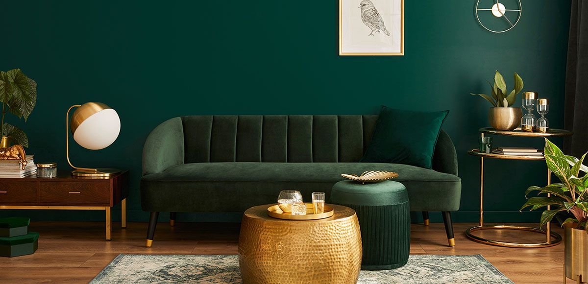 green sofa and ottoman with gold accents