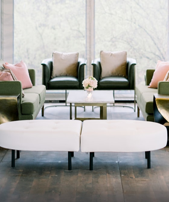 green seating with pink and gold decor at wedding reception in outdoor tent