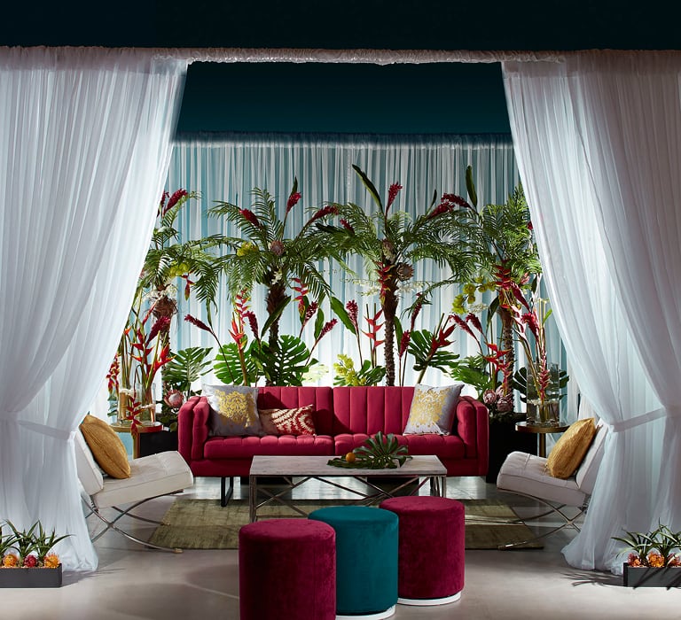 White drape cabana with red sofa and ottomans