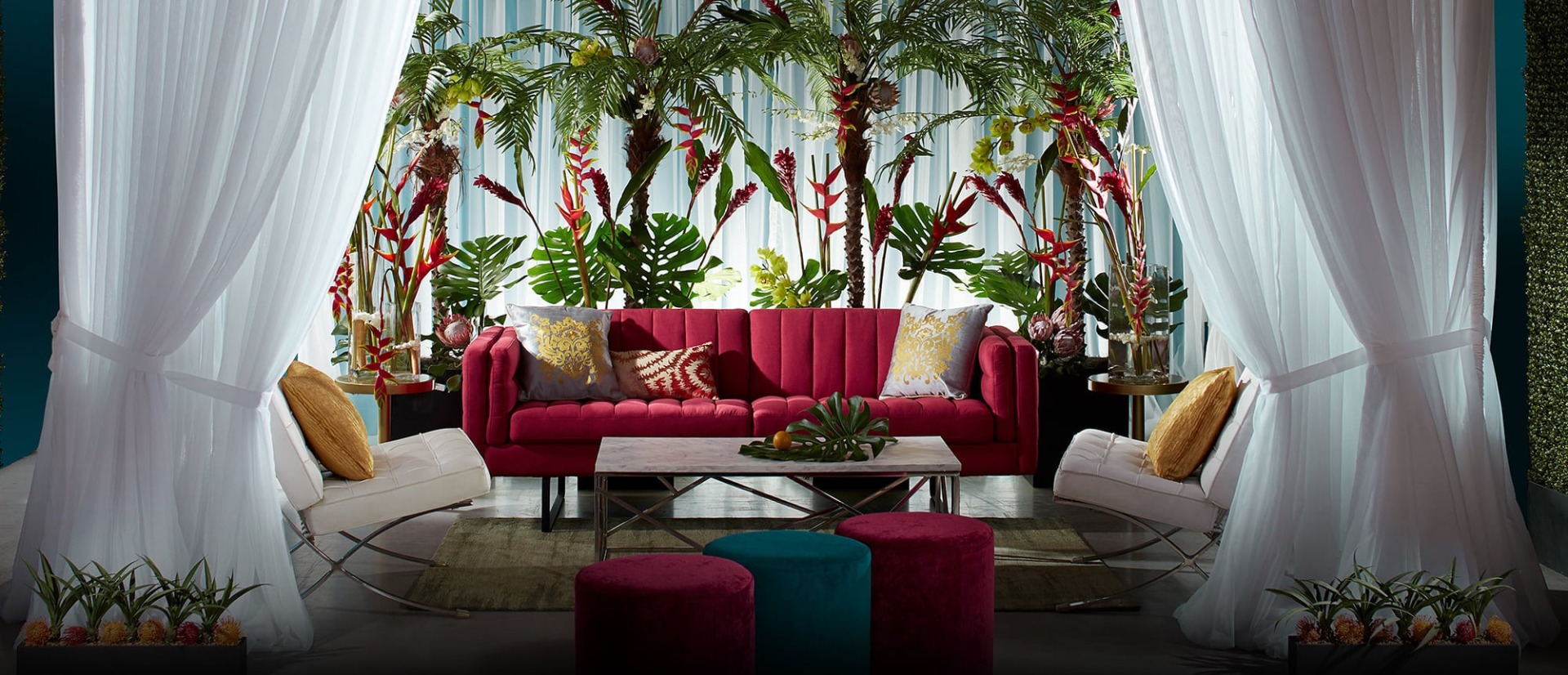 White drape cabana with red sofa and ottomans
