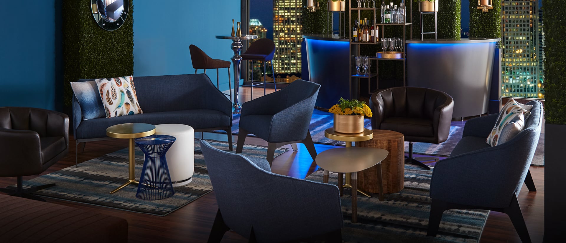 Cocktail reception with blue soft seating and bar with blue light