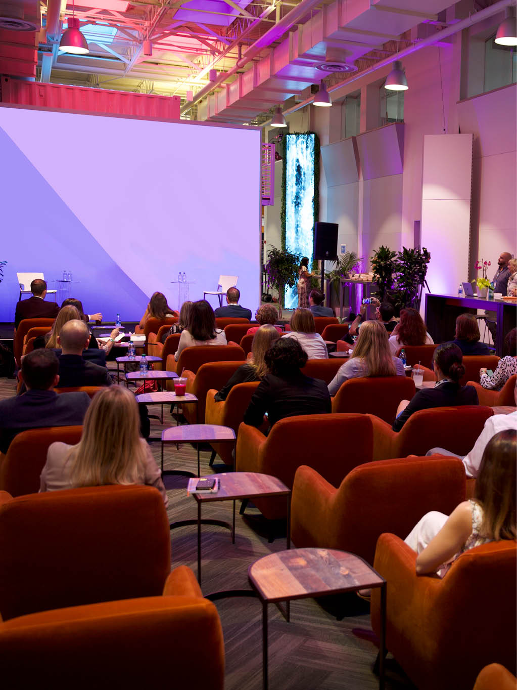 presentation with spice orange club chairs in front of screen