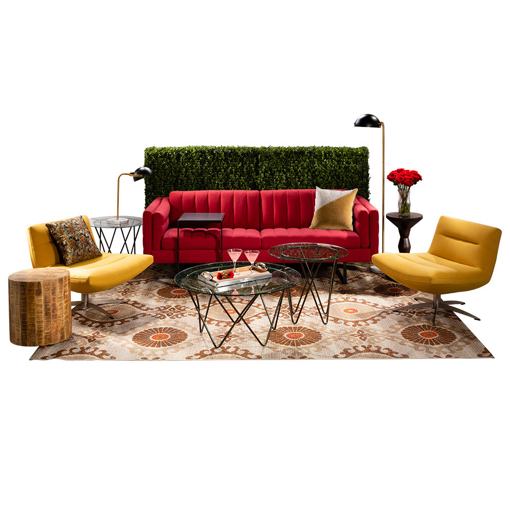 green soft seating set up with life like trees and orange accents