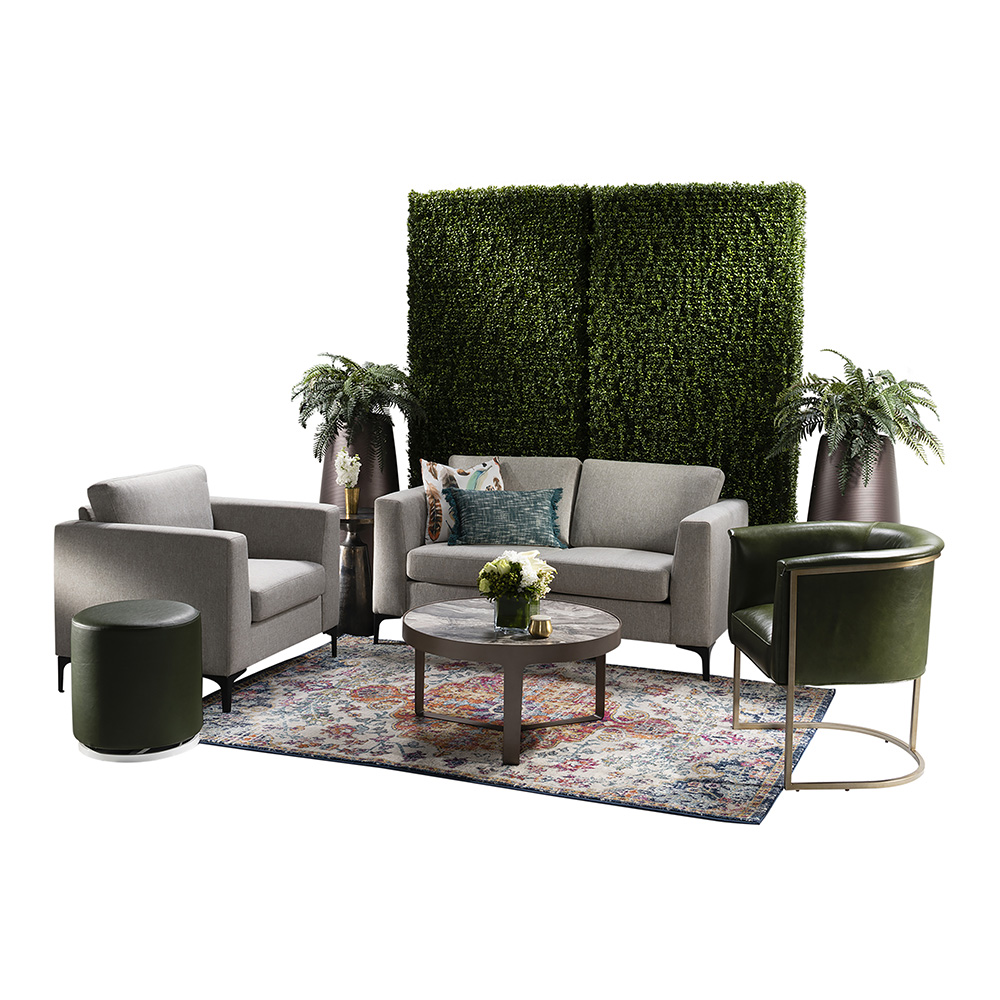 green soft seating set up with life like trees and orange accents