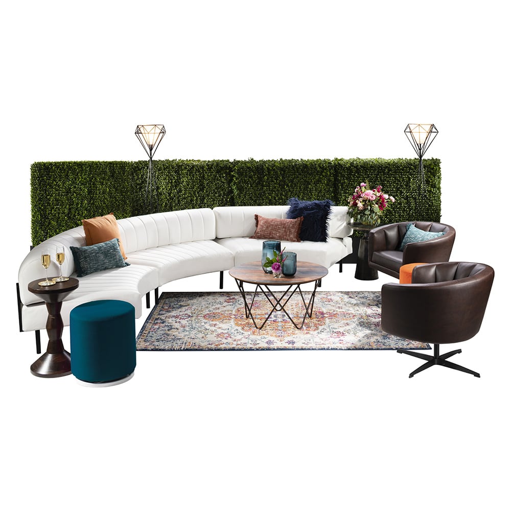 green soft seating set up with life like trees and orange accents