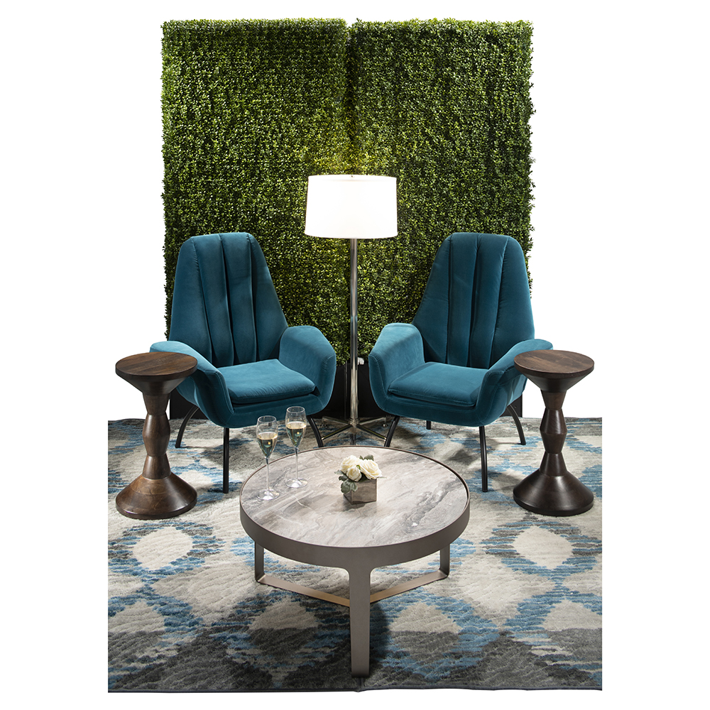 green soft seating set up with life like trees and orange accents