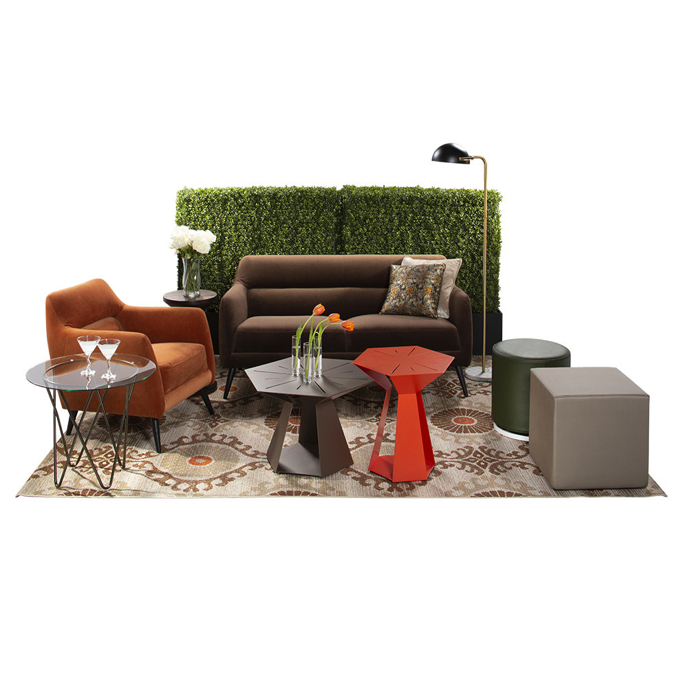 green soft seating set up with life like trees and orange accents